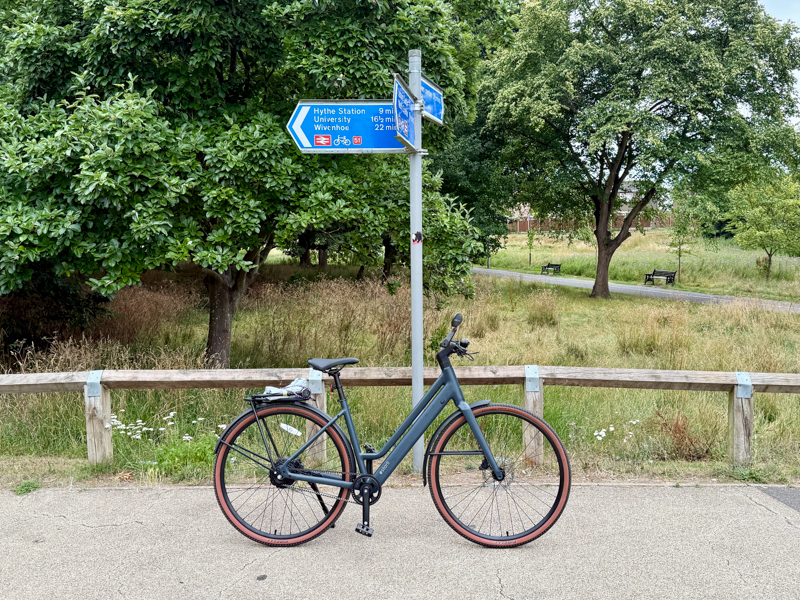 E-bike next to cycleway sign and greenery
